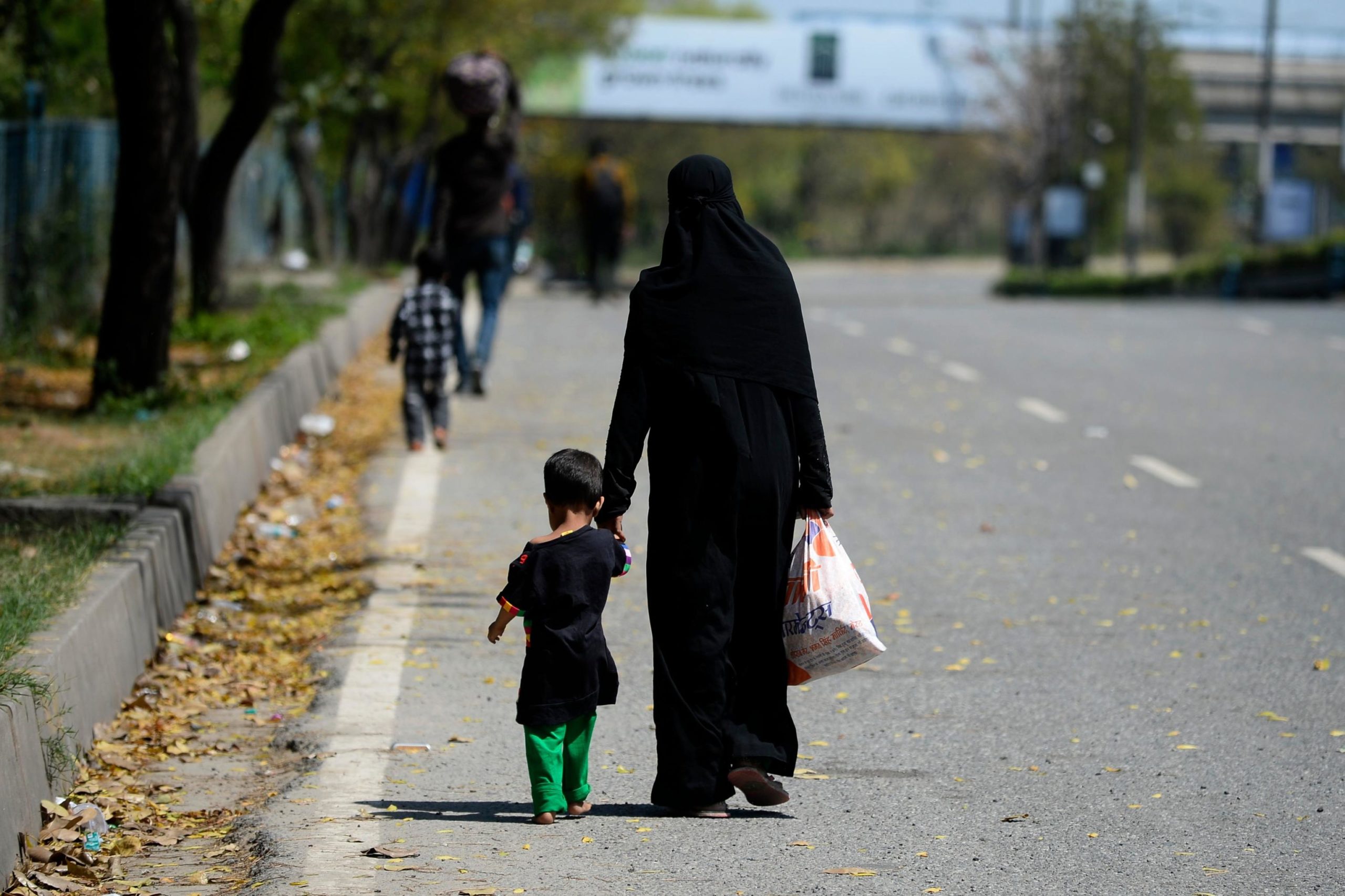 Una mamma e il suo bambino percorrono a piedi la strada verso casa Una mamma e il suo bambino percorrono a piedi la strada verso casa
