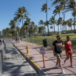 Alcuni turisti passeggiano sul lungomare ormai deserto Alcuni turisti passeggiano sul lungomare ormai deserto