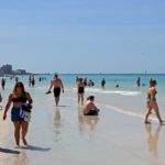 Persone che passeggiano sul bagnasciuga prima della chiusura Persone che passeggiano sul bagnasciuga prima della chiusura