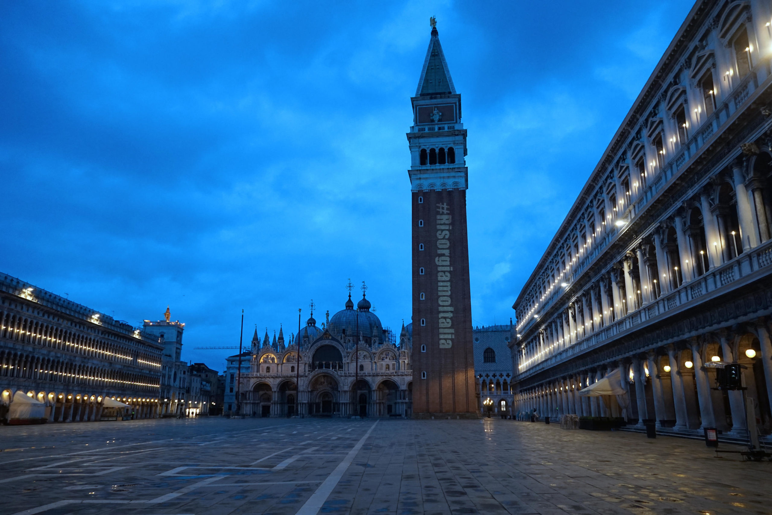 Il campanile della Basilica di San Marco illuminato con la scritta "Risorgiamo Italia"