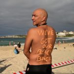 Un uomo posa di spalle alla riapertura della spiaggia australiana di Bondi Beach: "We got our beach back"!