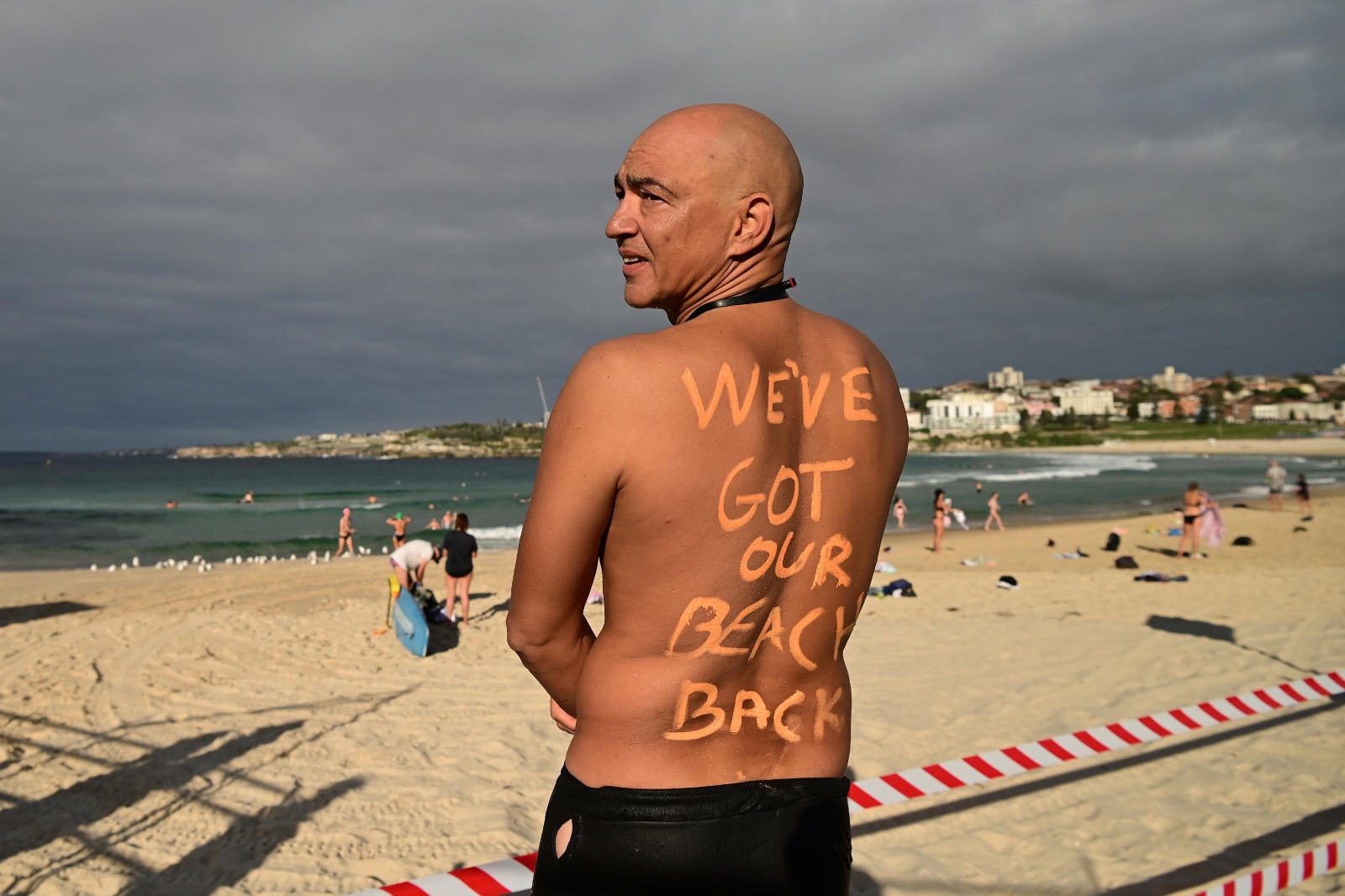 Un uomo posa di spalle alla riapertura della spiaggia australiana di Bondi Beach: "We got our beach back"!