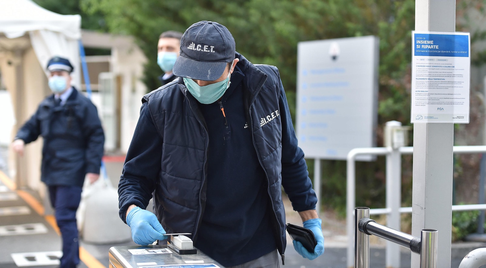 Gli impiegati, dopo aver passato i controlli, possono entrare in fabbrica. Uno per volta e rispettando le distanze di sicurezza.