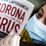 Una ragazza sfoglia un libro sul Coronavirus