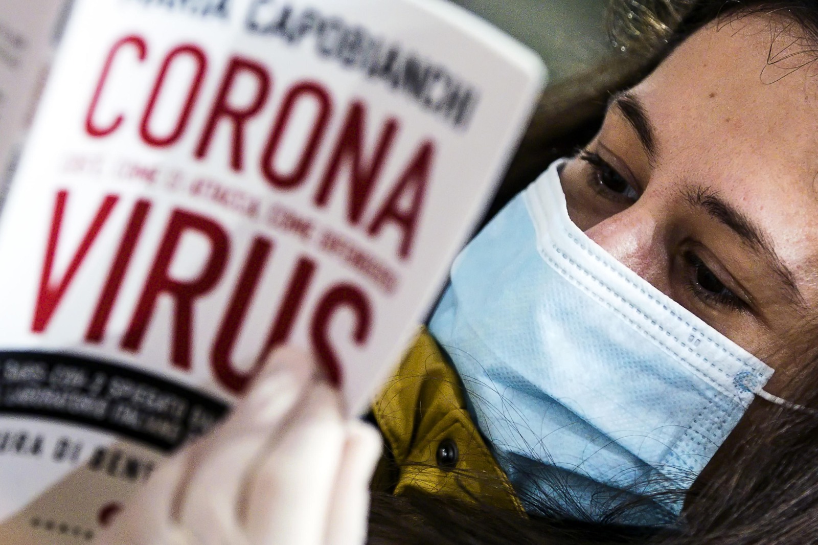 Una ragazza sfoglia un libro sul Coronavirus