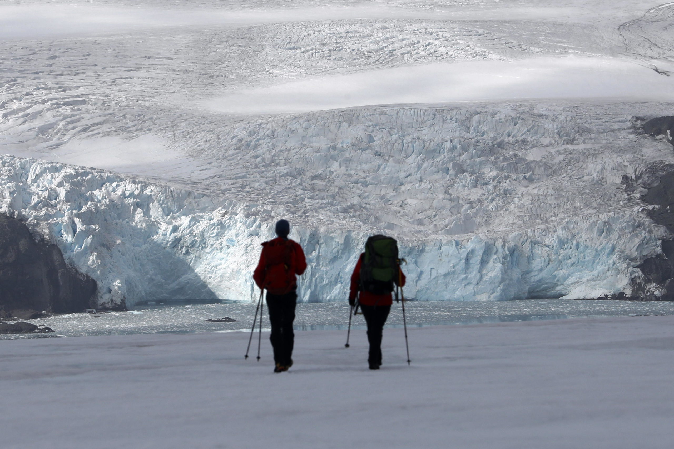 Due scienziati passeggiano lungo le colline ghiacciate dell'Antartide