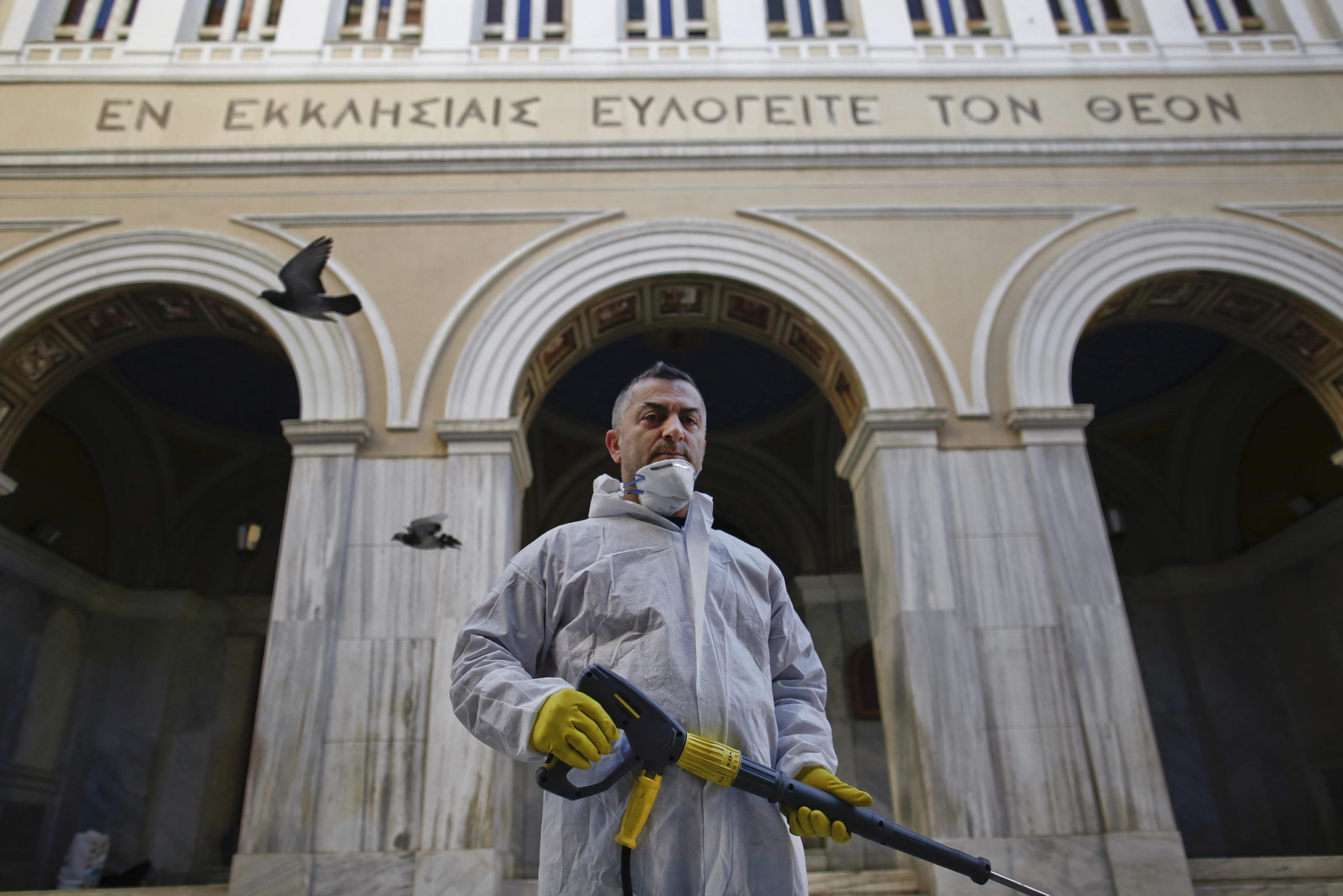Panagiotis Mpakoulas, lavoratore municipale, spruzza disinfettante fuori da una chiesa nel centro di Atene Panagiotis Mpakoulas, lavoratore municipale, spruzza disinfettante fuori da una chiesa nel centro di Atene