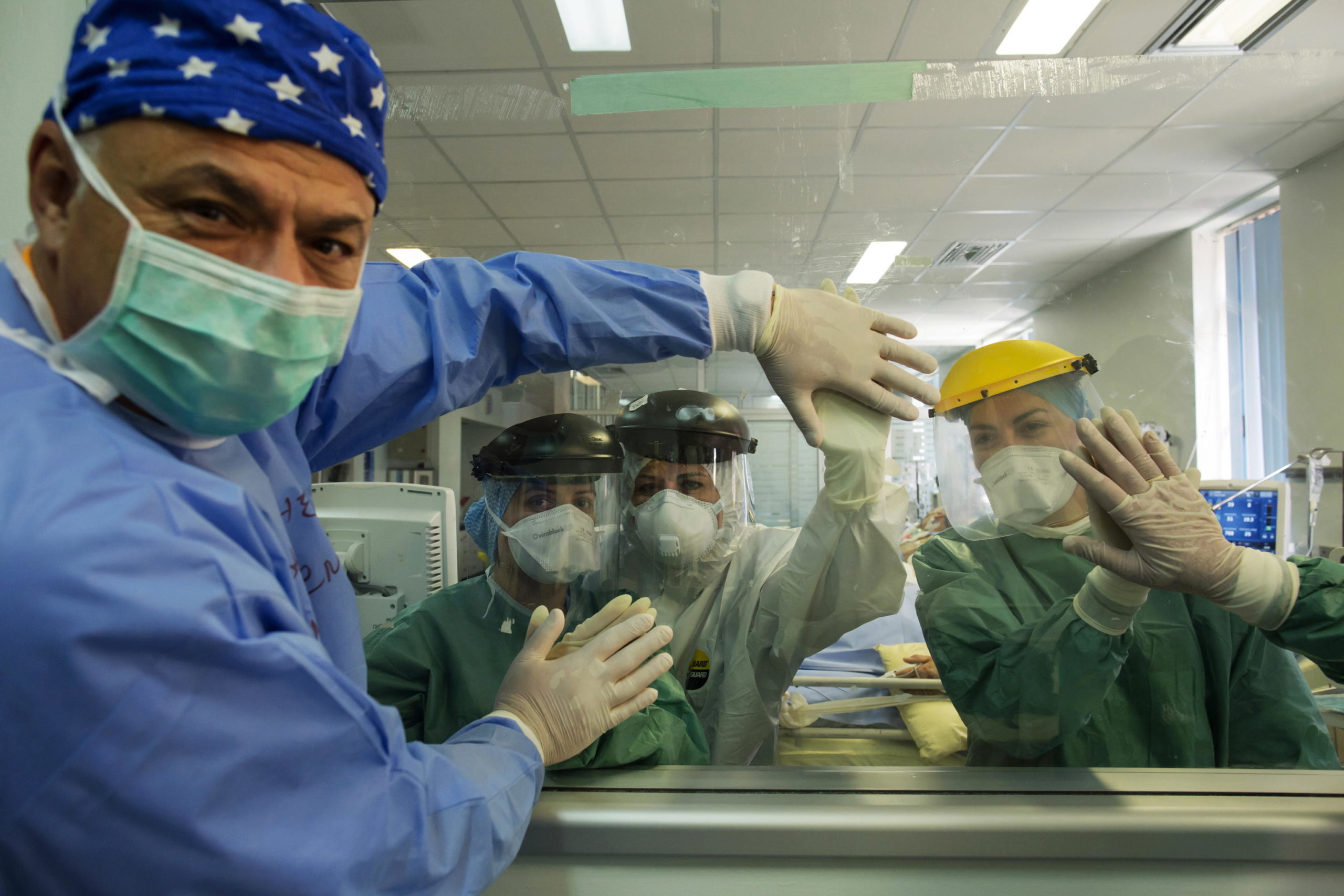 Gli infermieri toccano idealmente le mani dei medici dell'unità di terapia intensiva dell’ospedale Attikon ad Atene