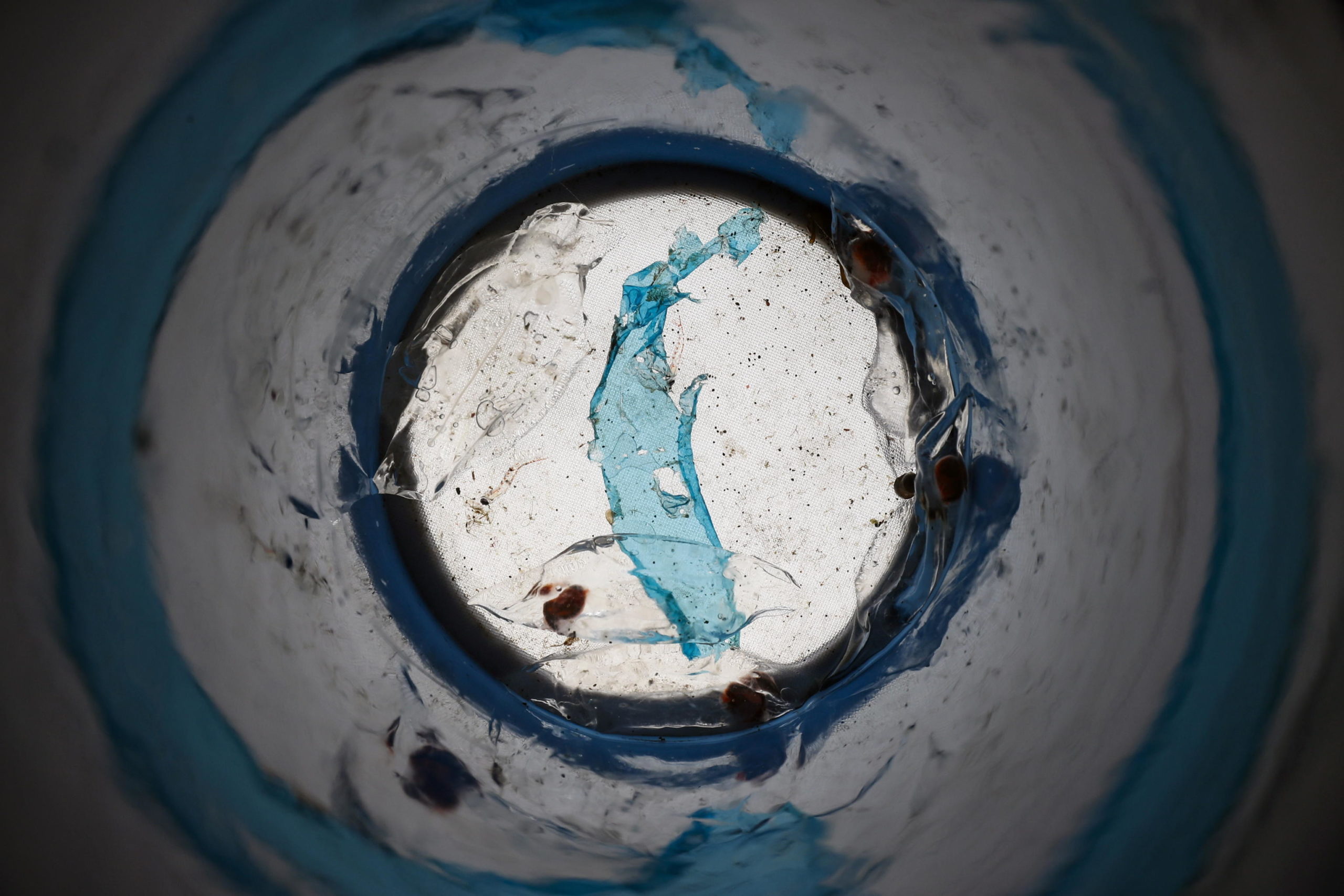 Sali e plastica blu visti attraverso un tubo di campionamento: sono indicatori di inquinamento e riscaldamento