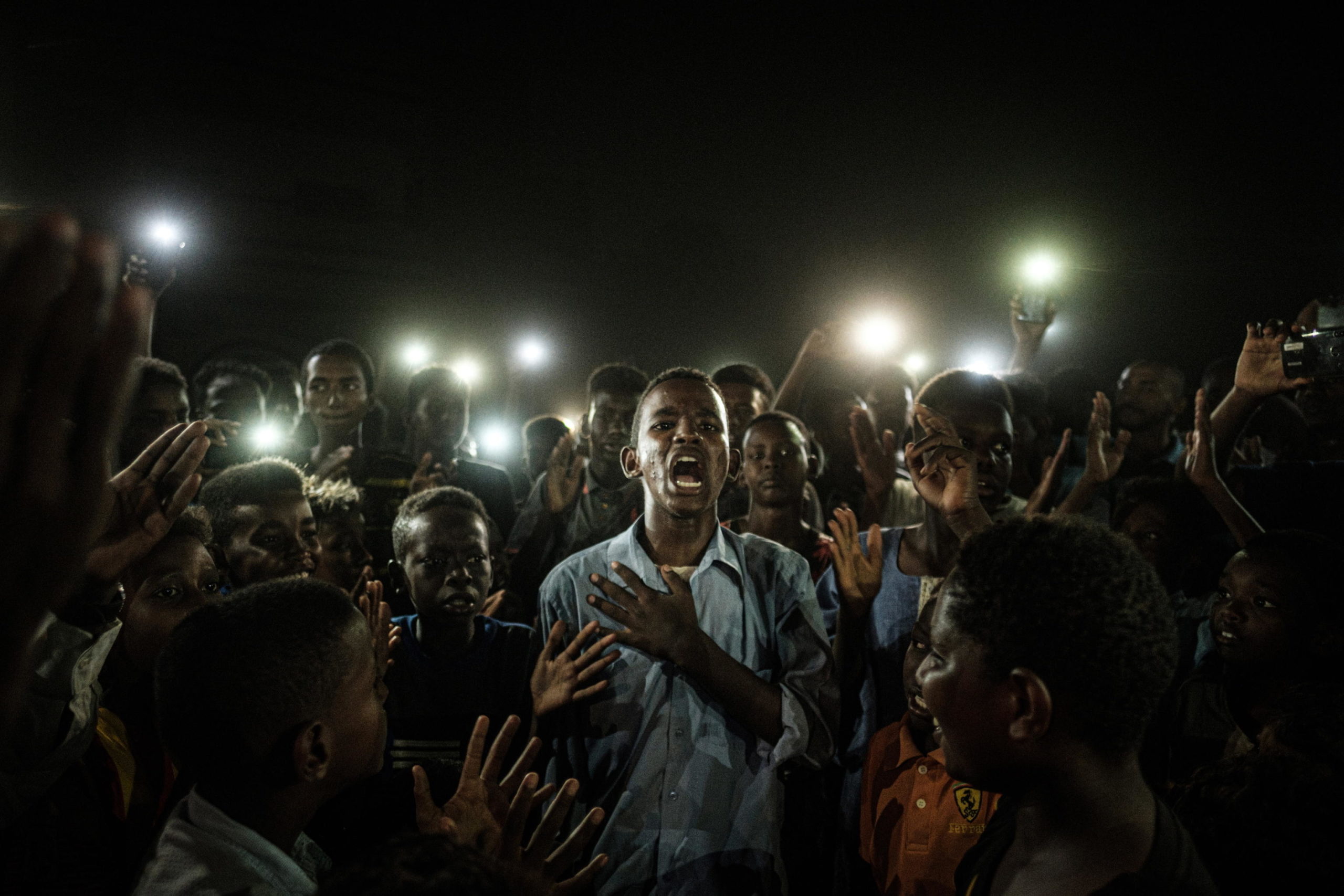 Primo premio "General news", un ragazzo illuminato dalle luci dei cellulari recita una poesia in Sudan Primo premio "General news", un ragazzo illuminato dalle luci dei cellulari recita una poesia in Sudan