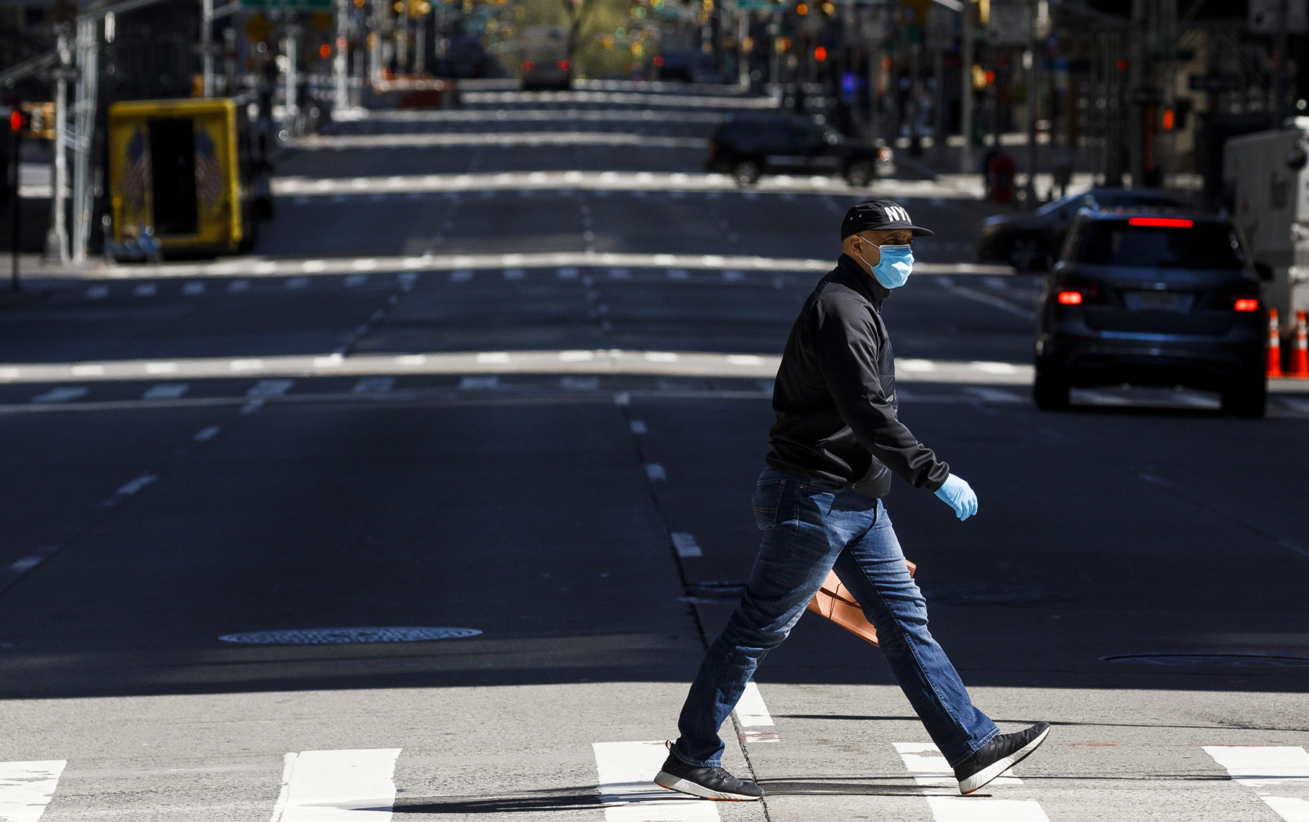 Un uomo con la mascherina attraversa la sesta strada a New York. Il governatore ha annunciato un ordine esecutivo che richiederà a tutti di indossarle fuori di casa