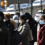Le persone indossano maschere protettive nel Bronx, a New York