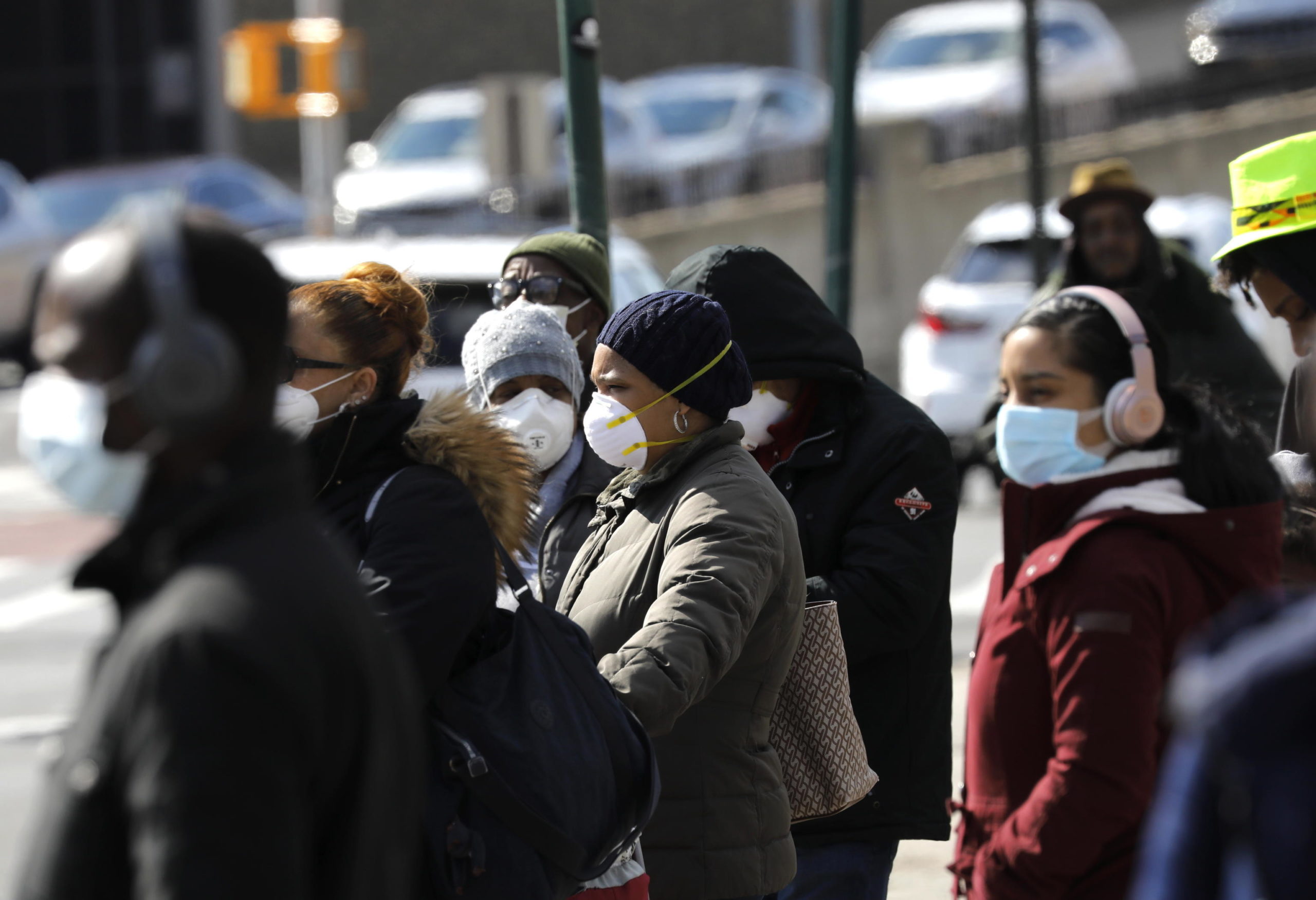 Le persone indossano maschere protettive nel Bronx, a New York