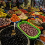Un commerciante palestinese vende olive e cetrioli al mercato di Gaza Un commerciante palestinese vende olive e cetrioli al mercato di Gaza