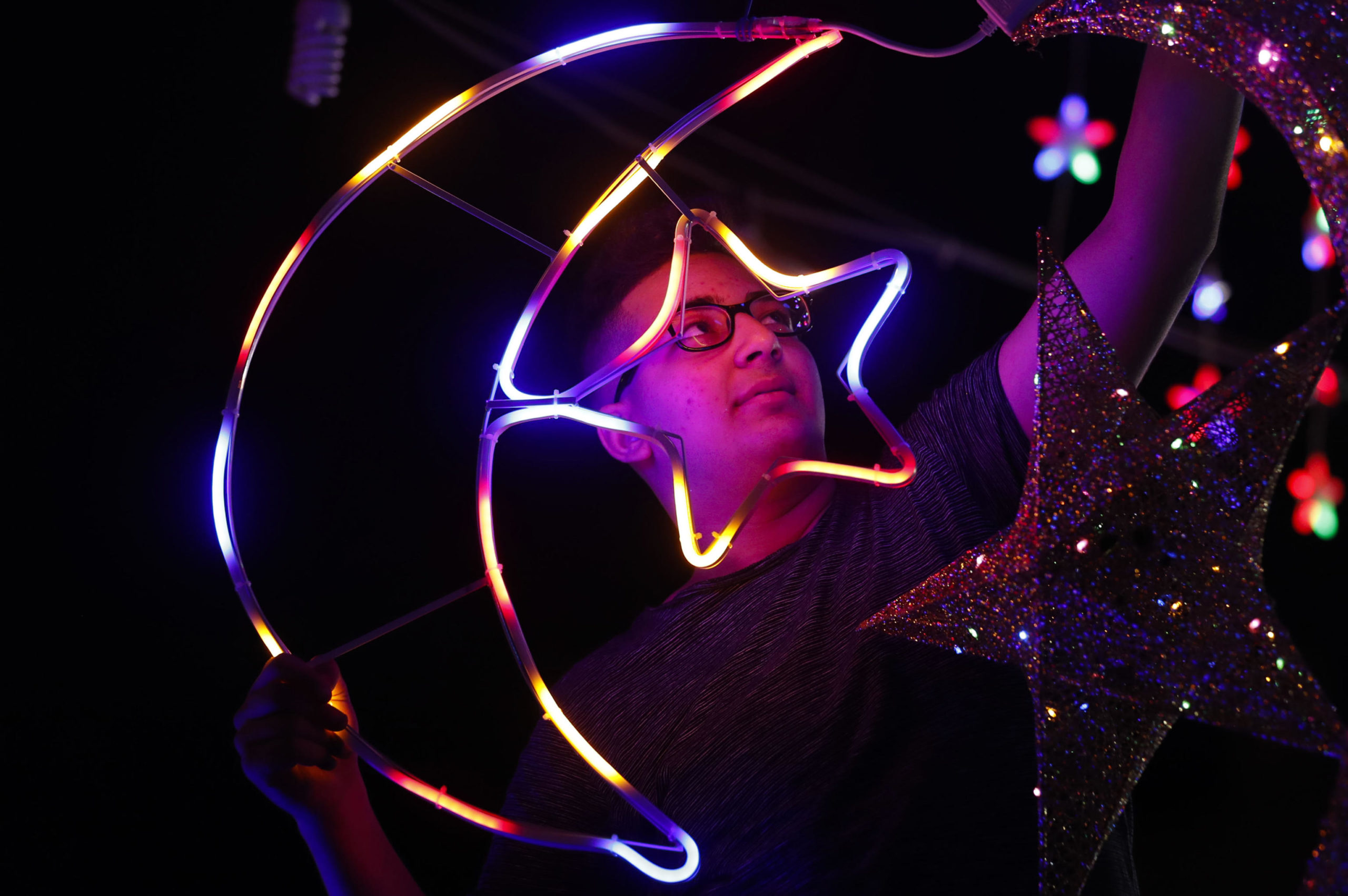 Un giovane palestinese appende luci decorative in un negozio Un giovane palestinese appende luci decorative in un negozio