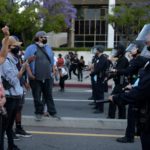 Manifestanti schierati di fronte alla polizia