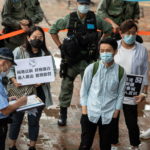 Un poliziotto multa un manifestante impassibile