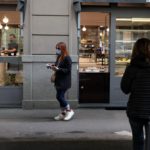 Una ragazza acquista un caffè da asporto in via Vincenzo Monti a Milano Una ragazza acquista un caffè da asporto in via Vincenzo Monti a Milano