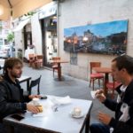 I clienti di un bar fanno colazione al tavolo senza mascherine a Roma