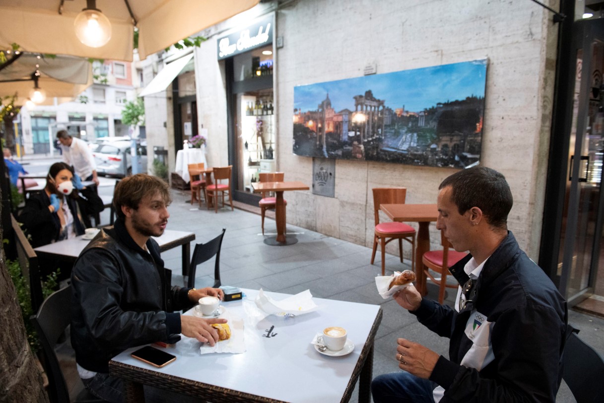 I clienti di un bar fanno colazione al tavolo senza mascherine a Roma