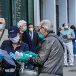 Persone in fila all'esterno di un comando di Polizia Municipale a Torino per pagare multe e permessi