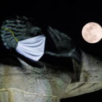 La "Luna dei fiori" splende alle spalle della statua del prete Antonio Montesino, che indossa una mascherina anti Coronavirus a Santo Domingo, nella Repubblica Domenicana