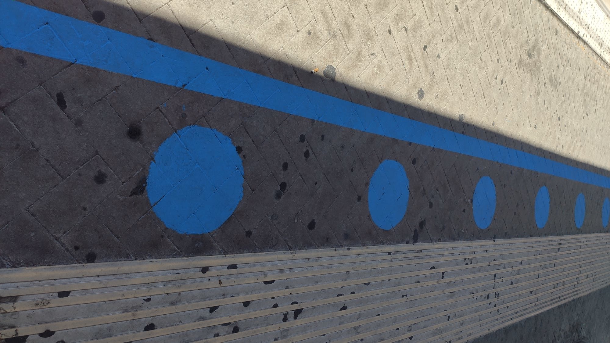 Una segnaletica blu indica dove posizionarsi quando si aspetta la metro sulla banchina Una segnaletica blu indica dove posizionarsi quando si aspetta la metro sulla banchina