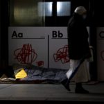 Un senzatetto si ripara davanti all'entrata di un negozio