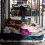 Un gruppo di senzatetto si ripara dal freddo