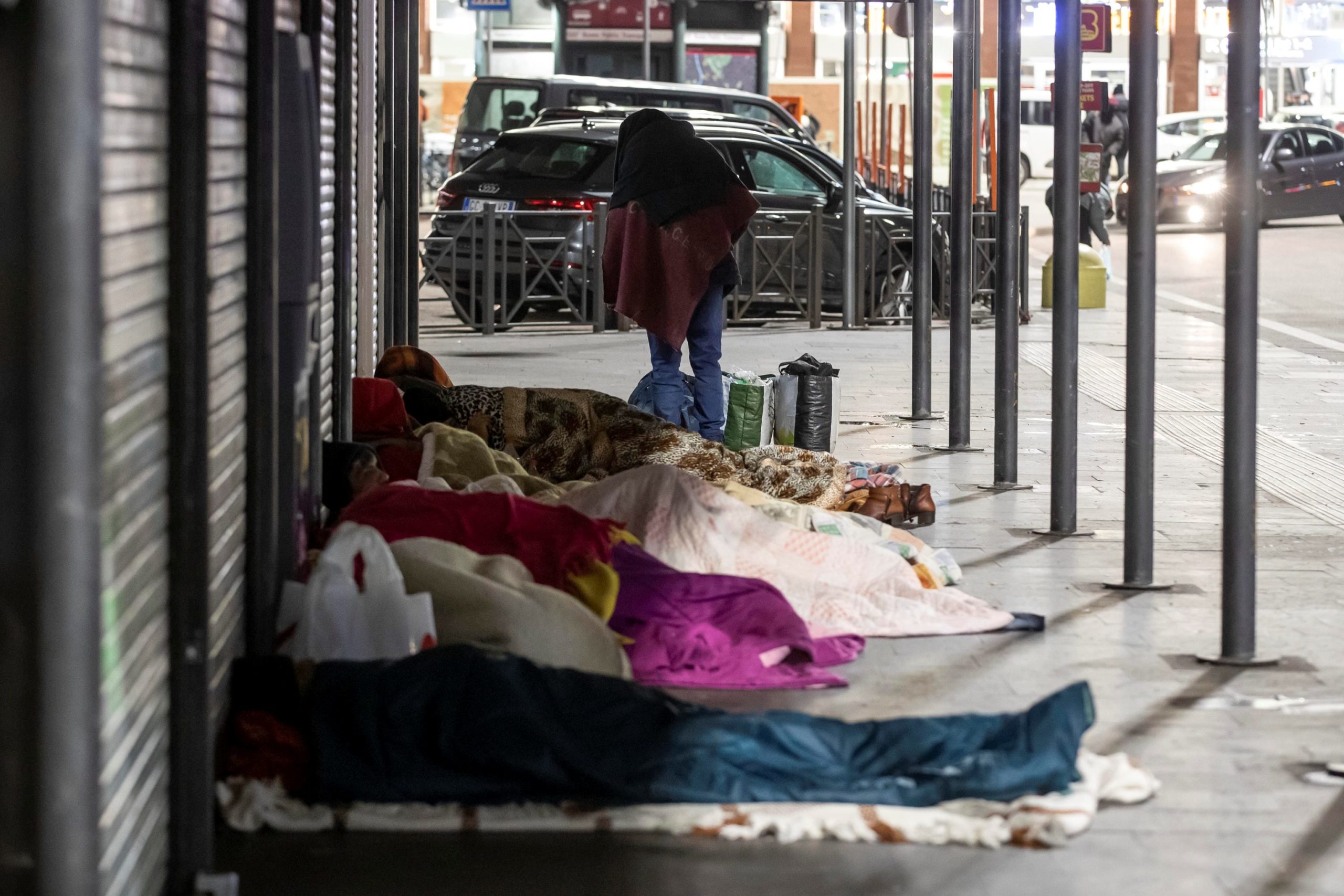 Un gruppo di senzatetto si ripara dal freddo