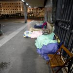 Alcuni senzatetto sdraiati sul marciapiede della stazione