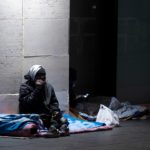 Un senzatetto ascolta la musica con delle cuffiette