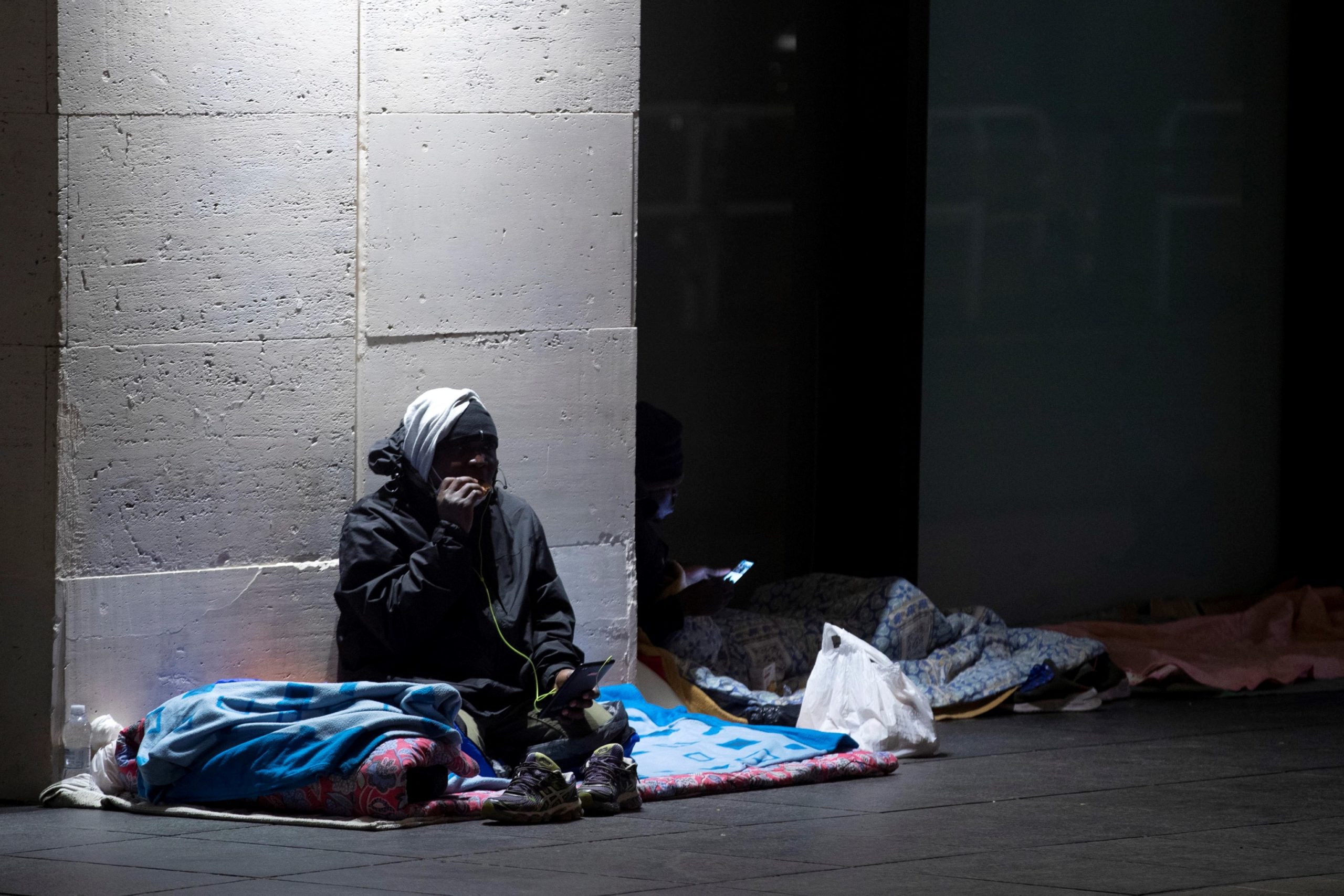 Un senzatetto ascolta la musica con delle cuffiette