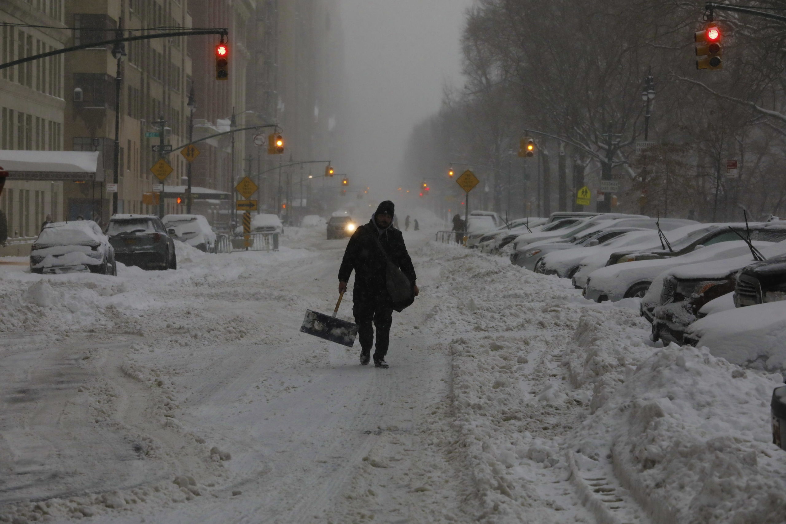 Un uomo cammina da solo per le strade innevate della città