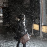 Una ragazza tra la neve che continua a cadere