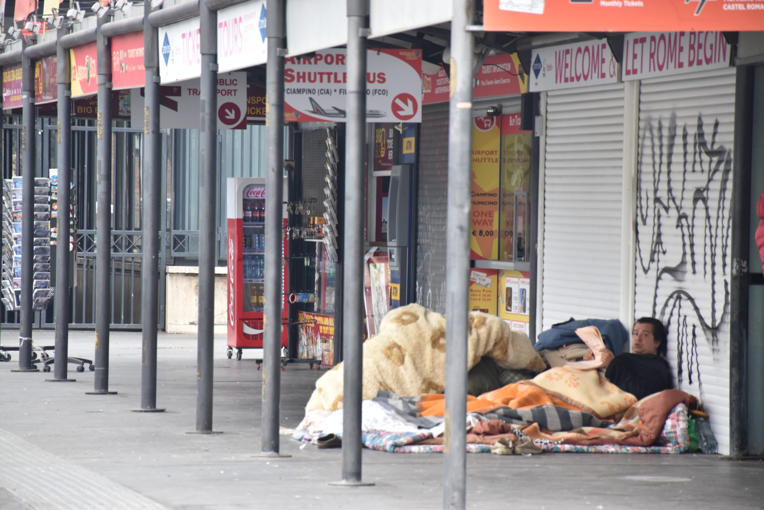 Un senzatetto sdraiato all'esterno della stazione Termini di Roma