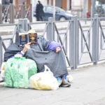 Un clochard intento a leggere un libro