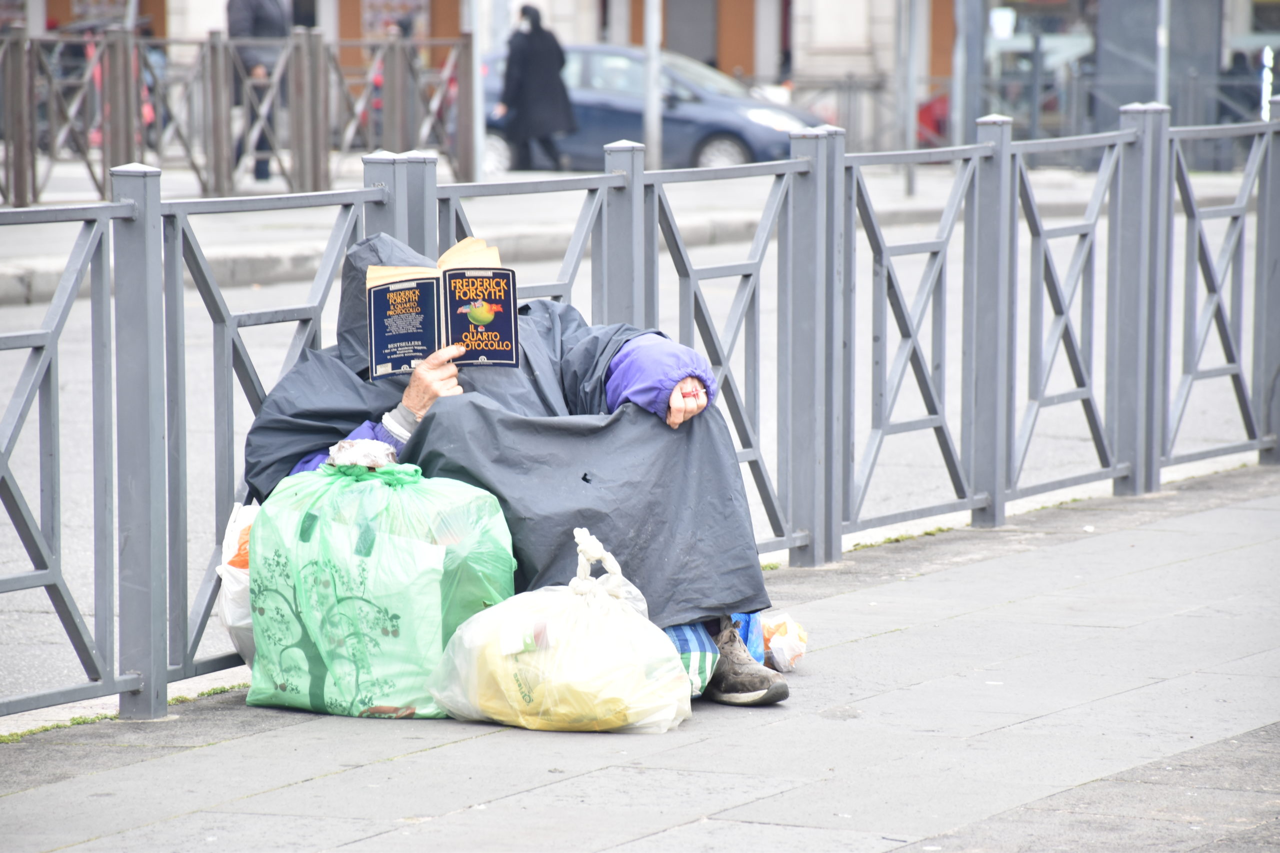 Un clochard intento a leggere un libro