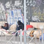 Alcuni senzatetto cercano di ripararsi dal freddo