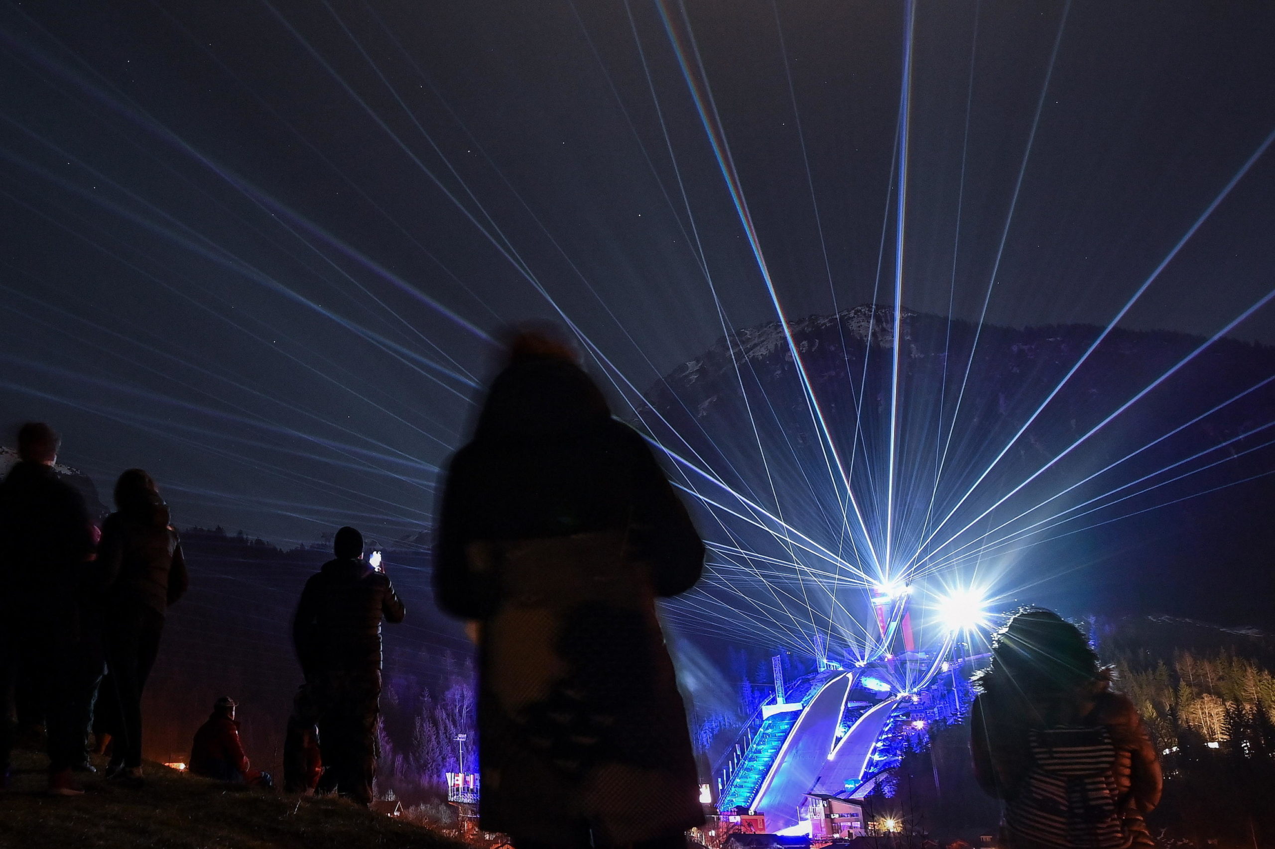 Gli spettatori sulla collina ammirano la pista illuminata