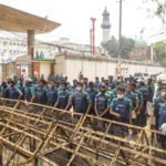 Ufficiali di polizia dietro una barricata posta per ostacolare la marcia degli studenti Ufficiali di polizia dietro una barricata posta per ostacolare la marcia degli studenti