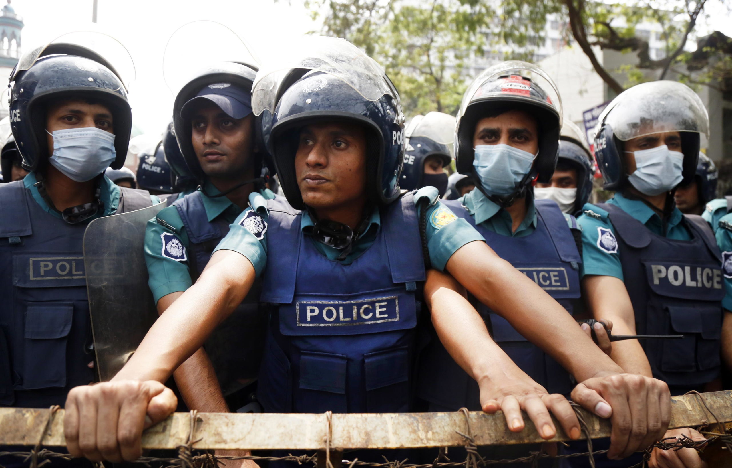Gli agenti di polizia osservano dietro una barricata gli studenti Gli agenti di polizia osservano dietro una barricata gli studenti