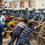 Gli studenti cercano di rimuovere una barricata della polizia Gli studenti cercano di rimuovere una barricata della polizia