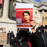 Una donna mostra una foto di Aung San Suu Kyi durante le proteste fuori dal Parlamento a Londra Una donna mostra una foto di Aung San Suu Kyi durante le proteste fuori dal Parlamento a Londra