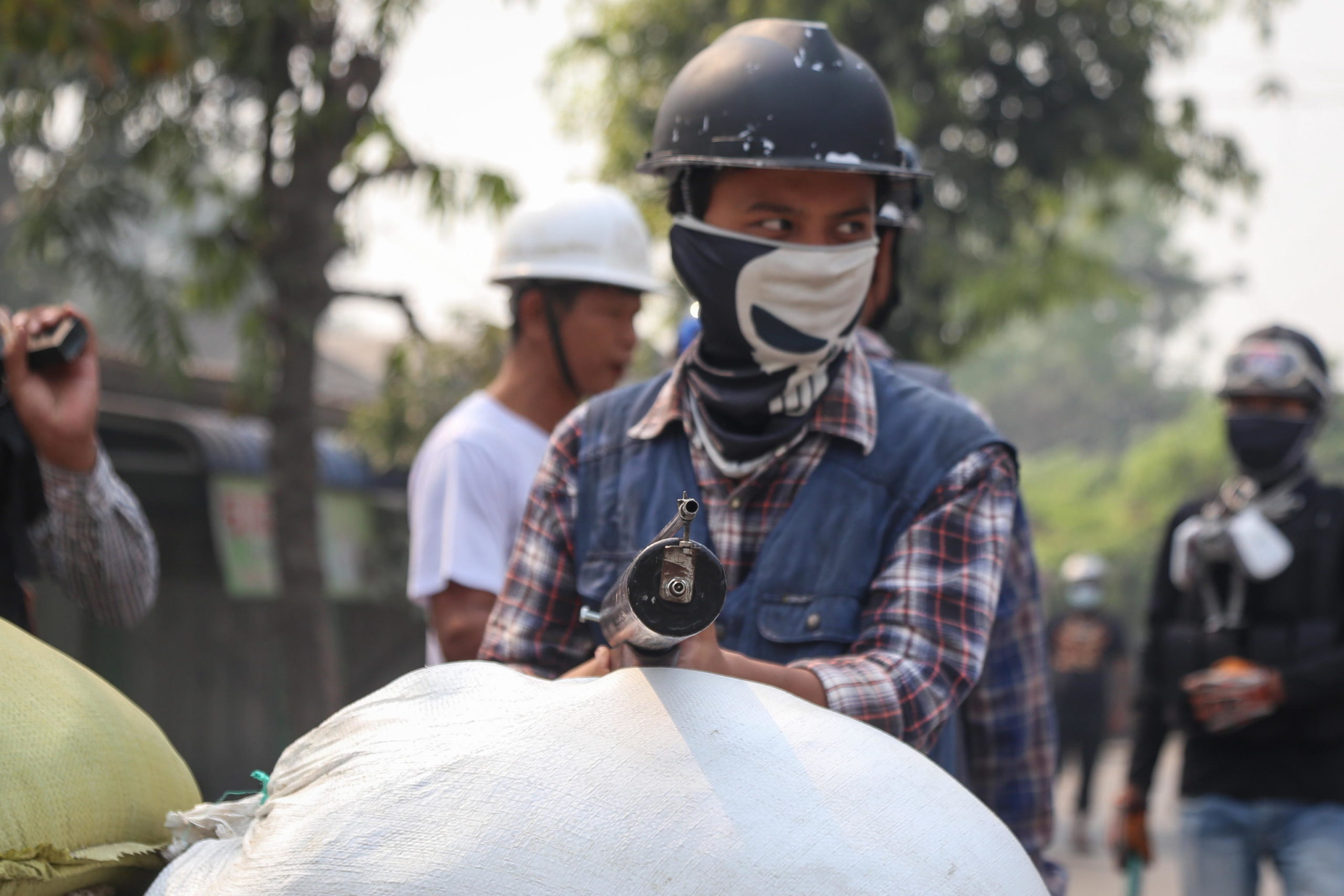 Un dimostrante impugna un'arma durante gli scontri a Mandalay Un dimostrante impugna un'arma durante gli scontri a Mandalay