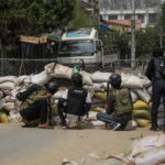 Manifestanti si proteggono dietro una barricata nel corso delle proteste a Mandalay Manifestanti si proteggono dietro una barricata nel corso delle proteste a Mandalay