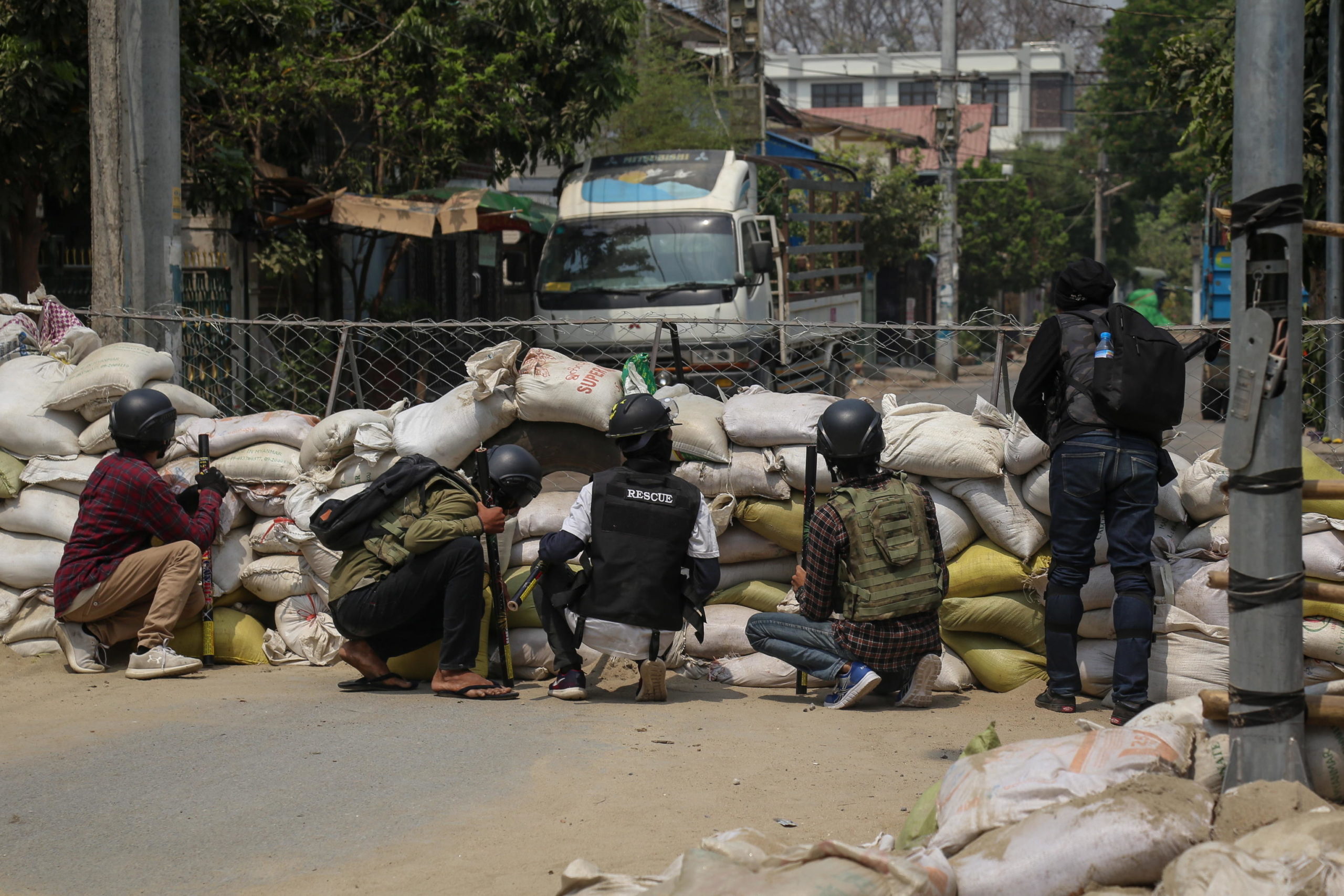 Manifestanti si proteggono dietro una barricata nel corso delle proteste a Mandalay Manifestanti si proteggono dietro una barricata nel corso delle proteste a Mandalay