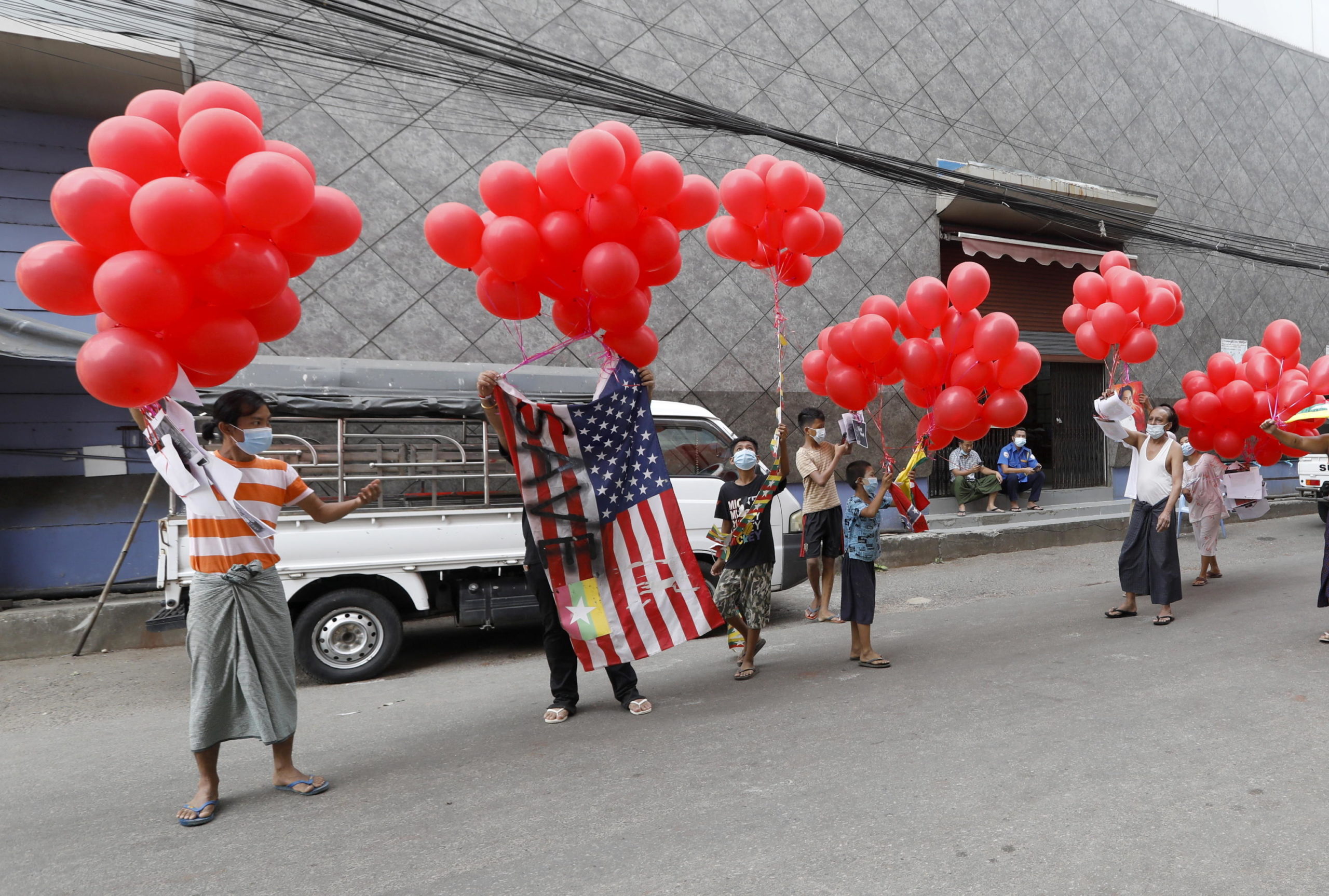 Manifestanti a Yangon sventolano una bandiera americana che riporta la scritta "Save"