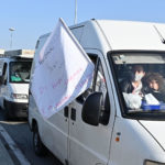 Gli ambulanti nel traffico con bandiere di protesta