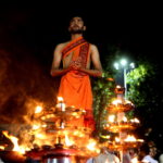 Un sacerdote in preghiera rivolto verso il fiume Narmada